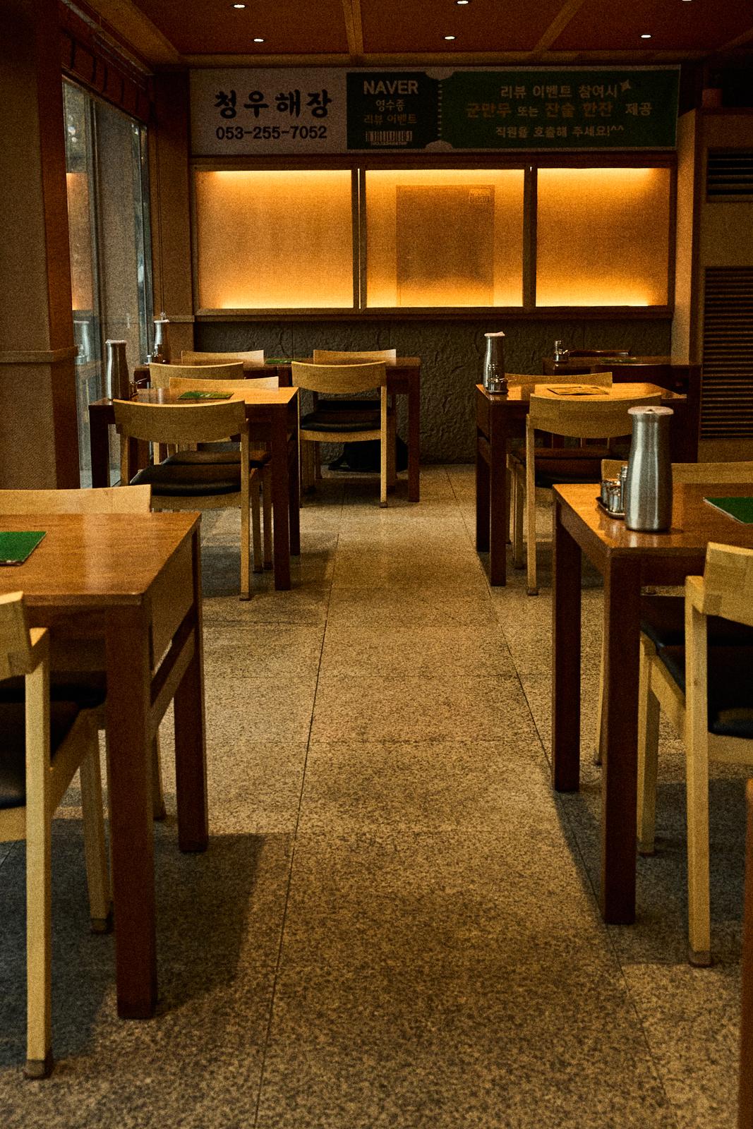 청우해장 테이블 사이 통로와 간접조명 벽면